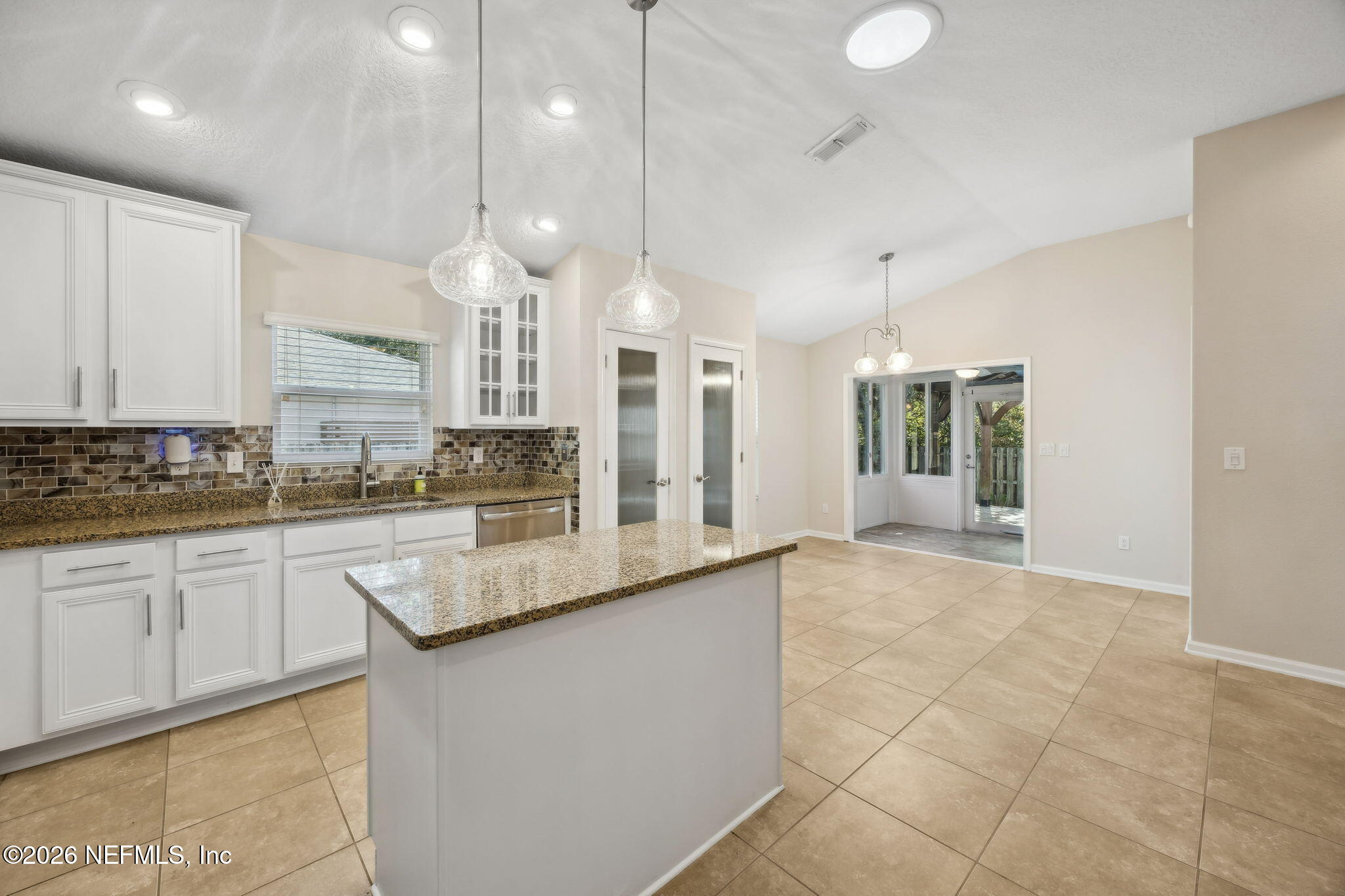 1602 Indigo Street Fernandina Beach, FL 32034 - Photo 13 of 35 a large kitchen with granite countertop a large kitchen island white cabinetry and a granite counter tops