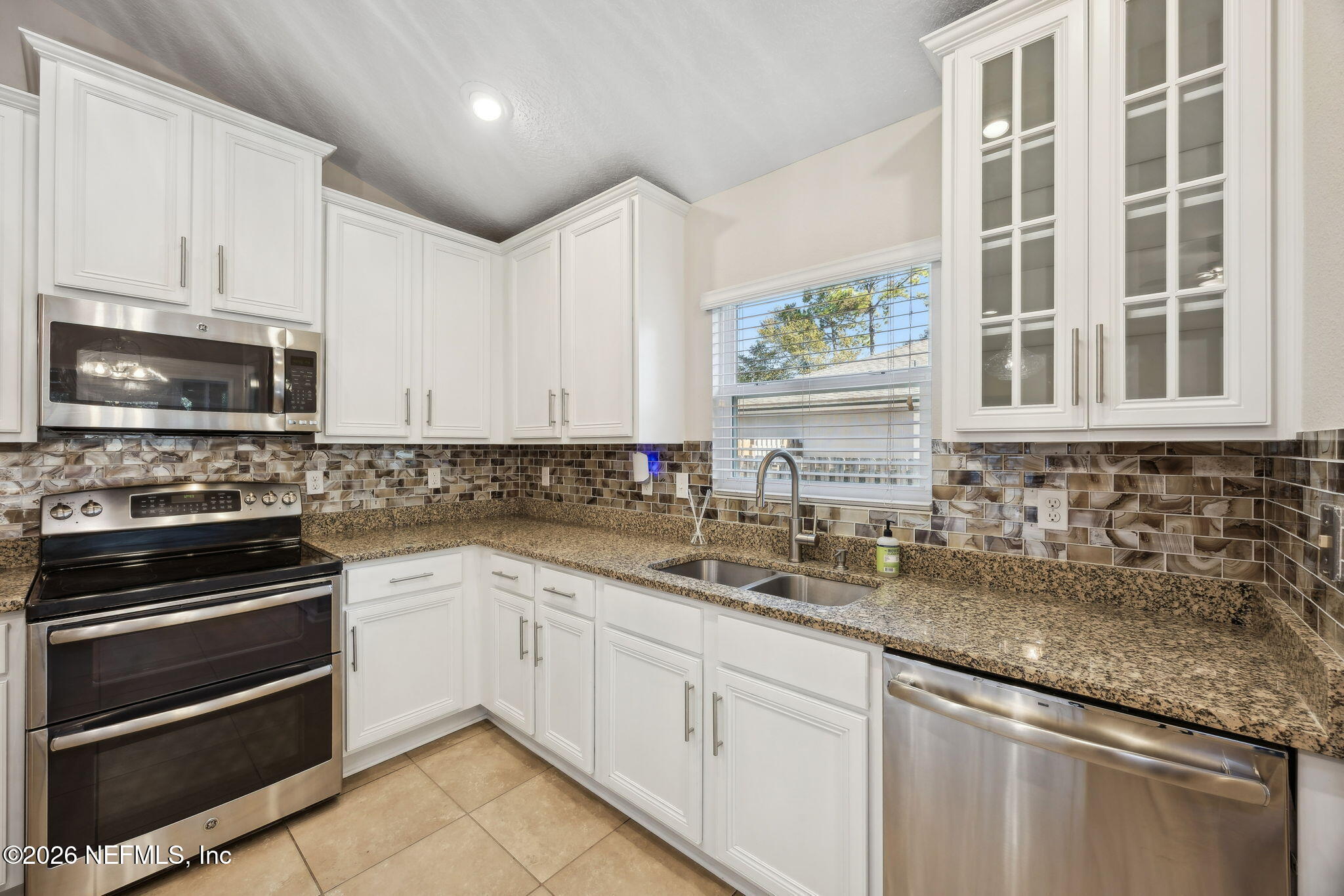 1602 Indigo Street Fernandina Beach, FL 32034 - Photo 14 of 35 a kitchen with granite countertop a sink stainless steel appliances and cabinets