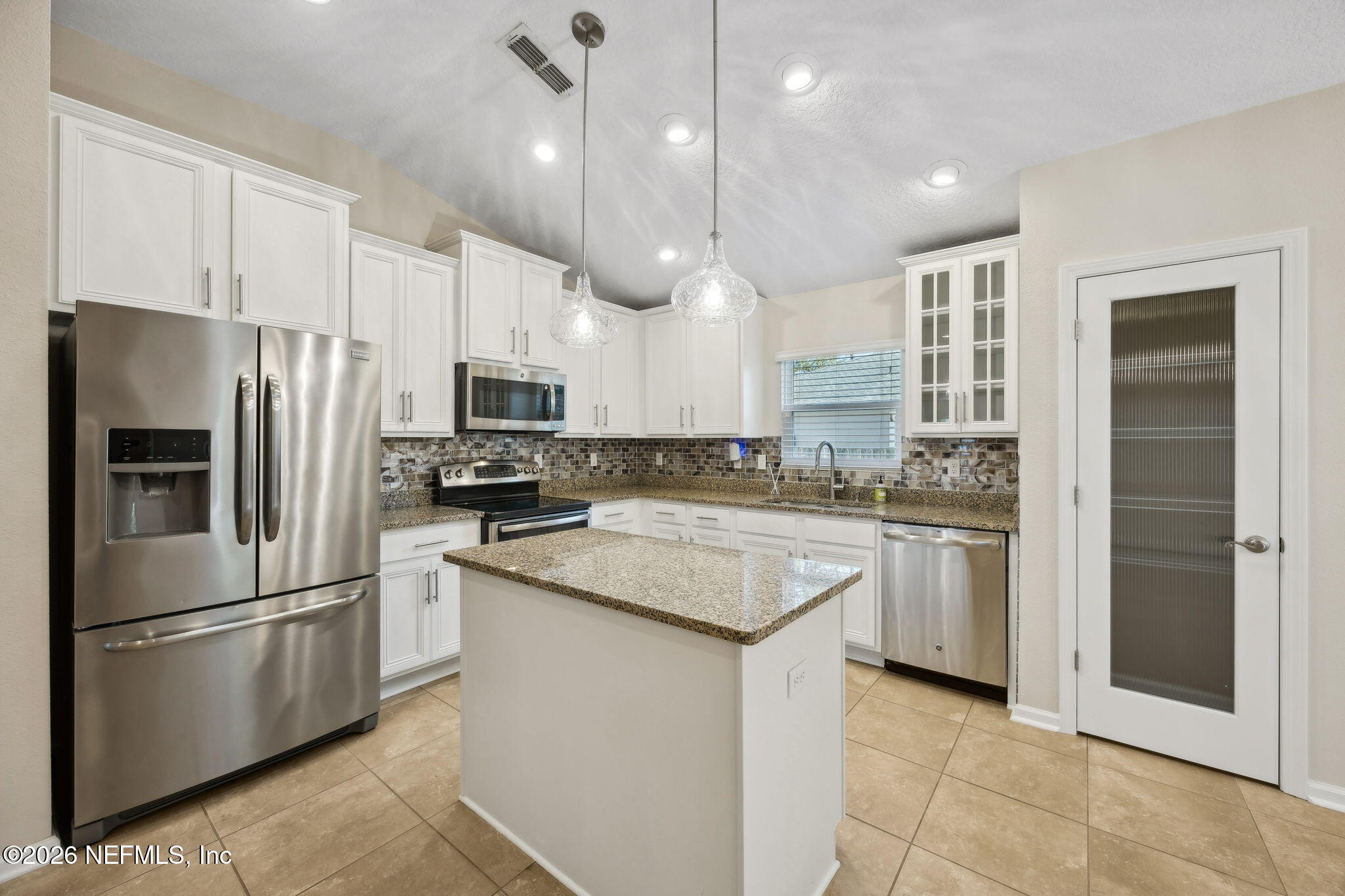 1602 Indigo Street Fernandina Beach, FL 32034 - Photo 7 of 35 a kitchen with stainless steel appliances granite countertop a refrigerator a stove a sink and a microwave