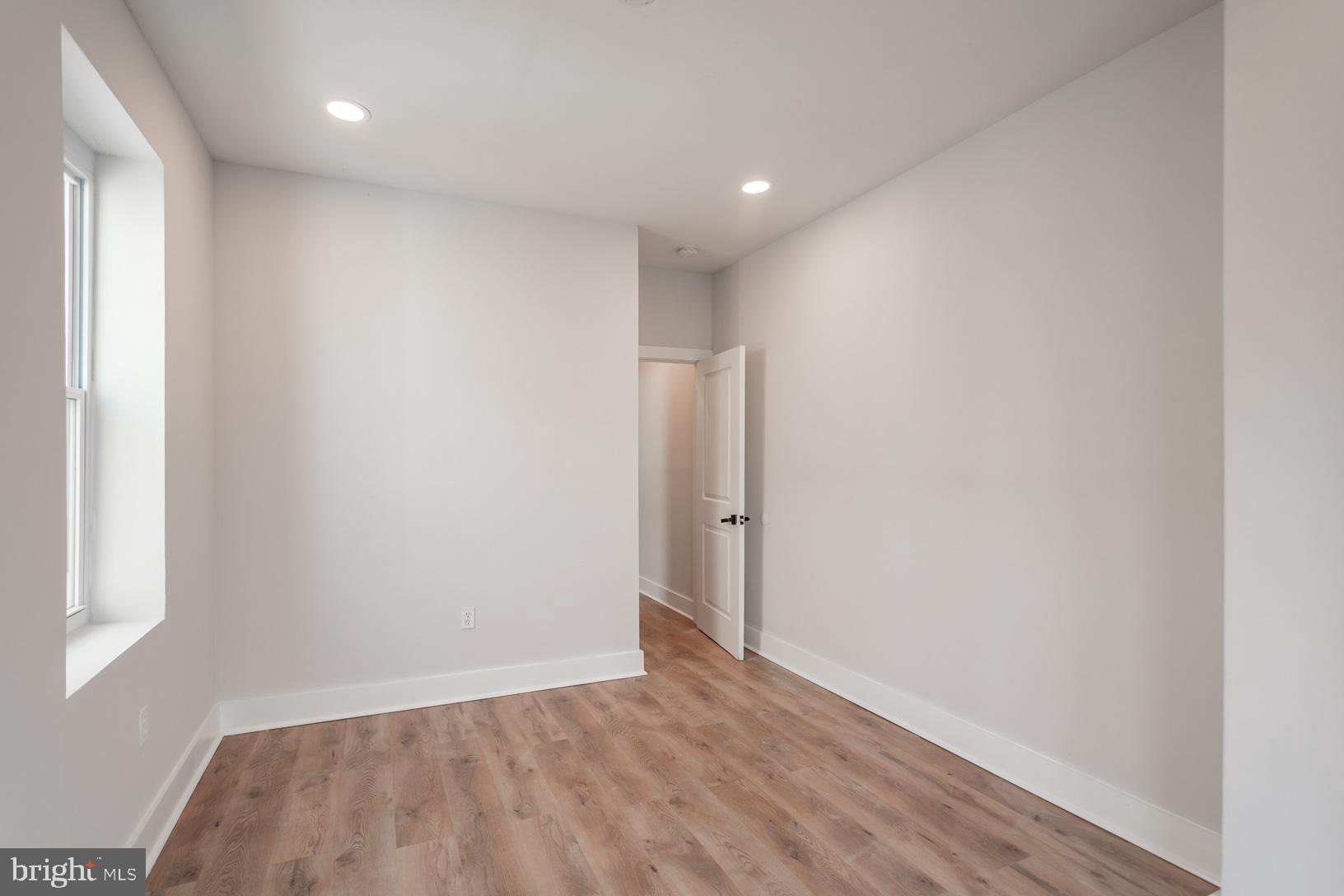 5111 Willows Avenue, Unit B Philadelphia, PA 19143 - Photo 14 of 18 a view of an empty room with wooden floor and a window