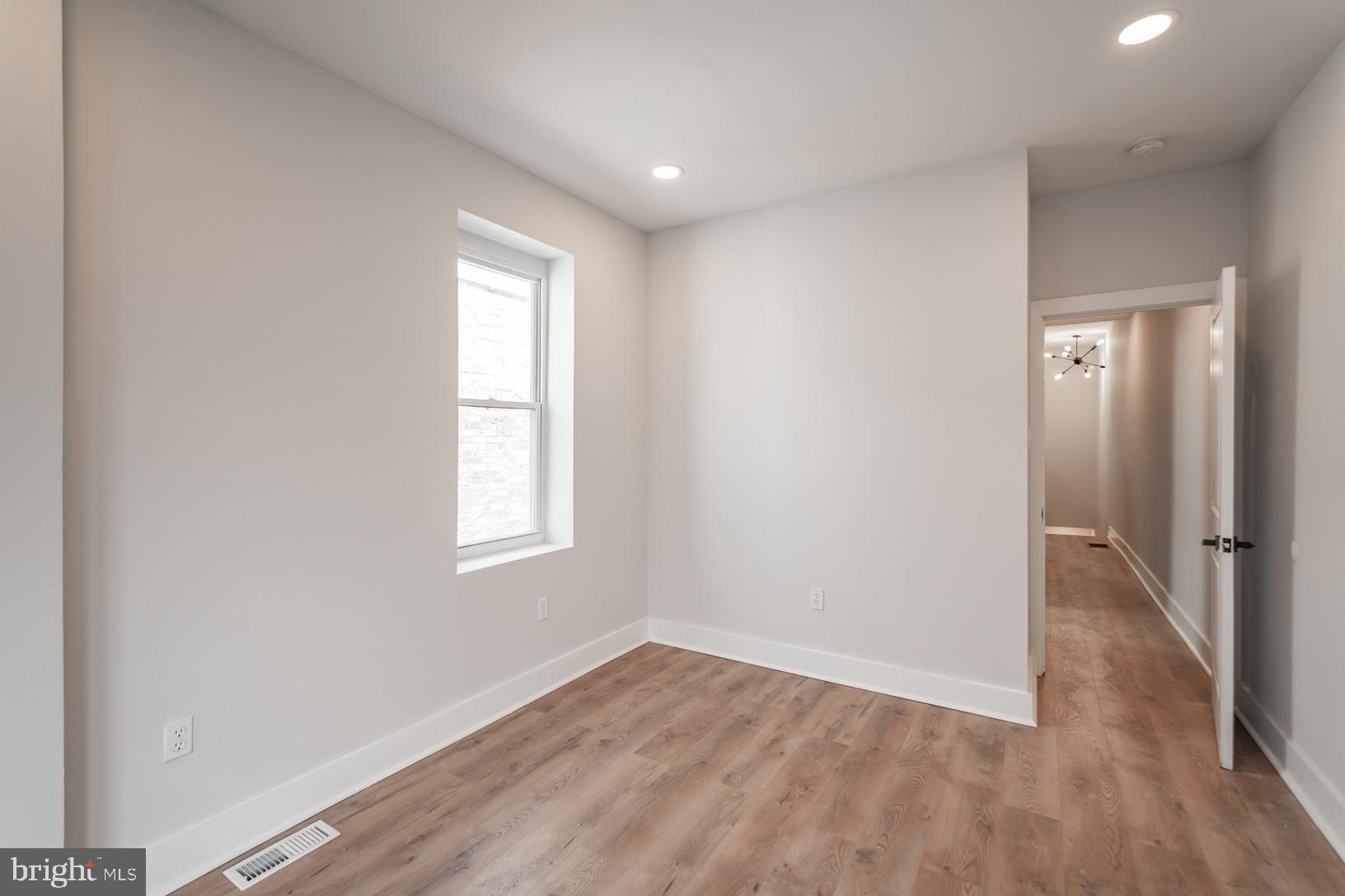 5111 Willows Avenue, Unit B Philadelphia, PA 19143 - Photo 15 of 18 an empty room with wooden floor and window