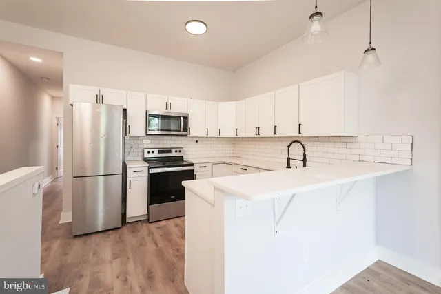 a kitchen with a sink a refrigerator a microwave and cabinets