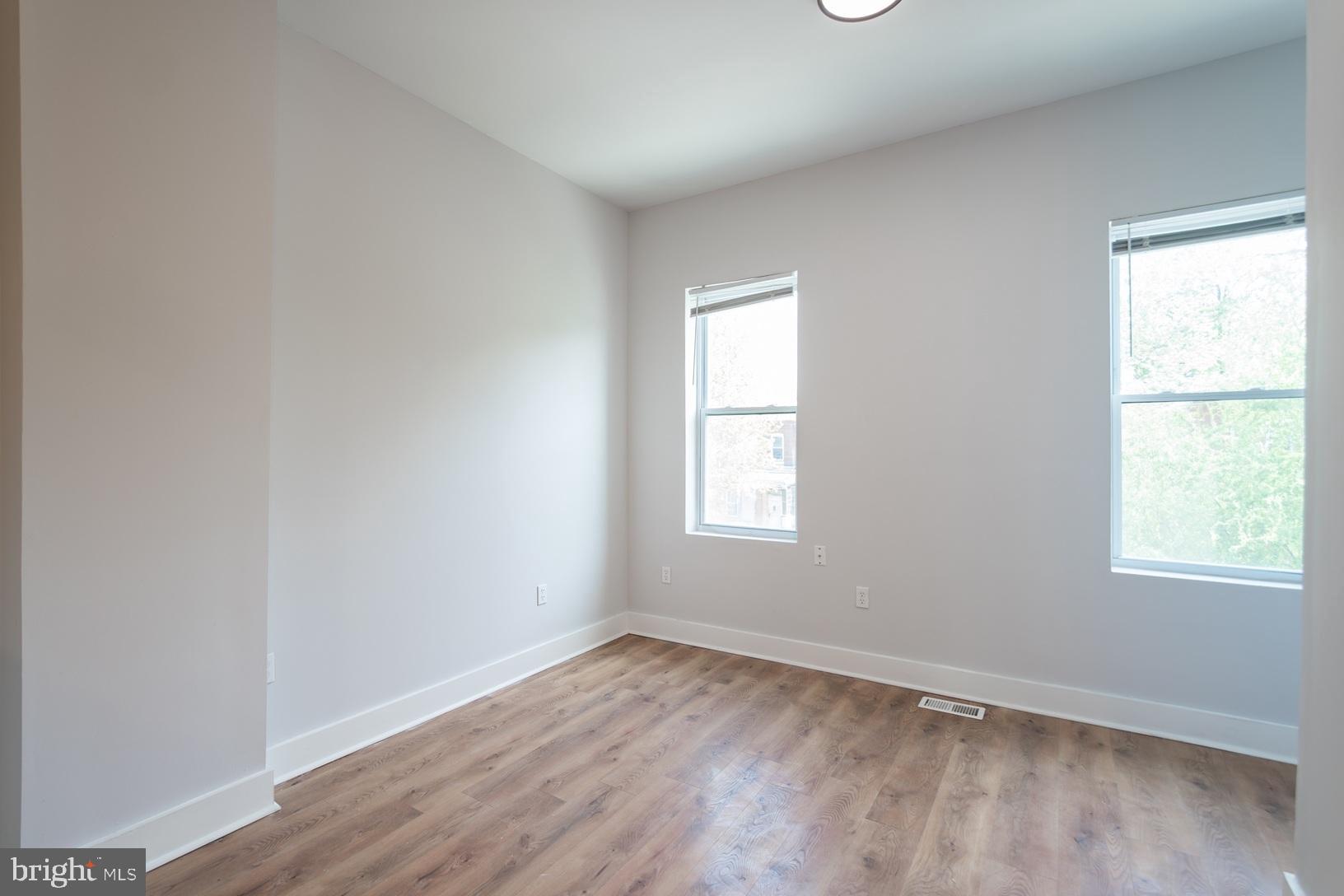 5111 Willows Avenue, Unit B Philadelphia, PA 19143 - Photo 6 of 18 an empty room with wooden floor and windows