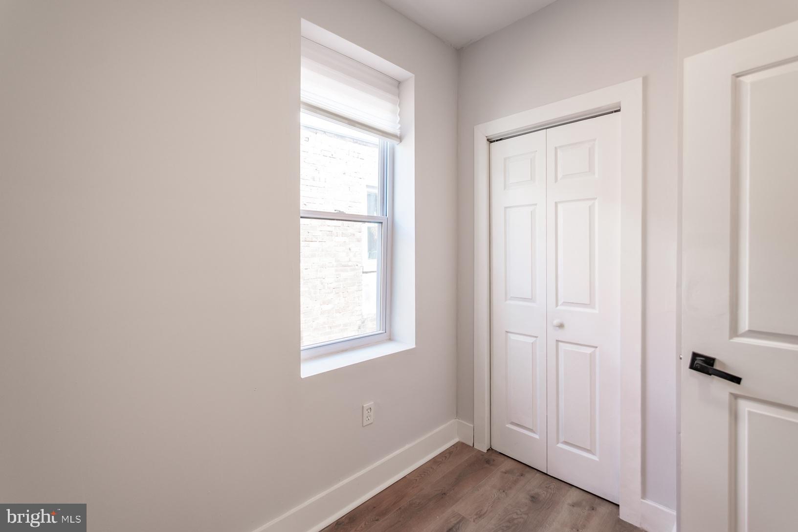 5111 Willows Avenue, Unit B Philadelphia, PA 19143 - Photo 10 of 18 an empty room with wooden floor closet and windows