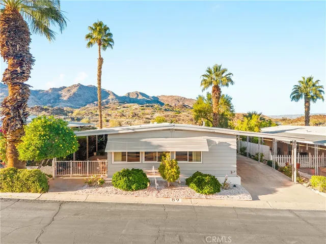 a front view of a house with a garden and potted plants