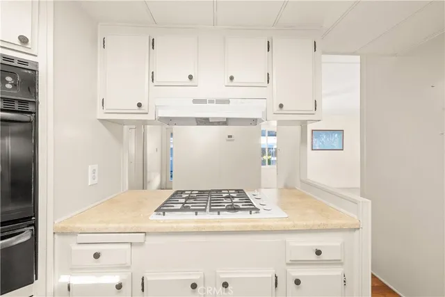 a kitchen with granite countertop a sink stove and cabinets