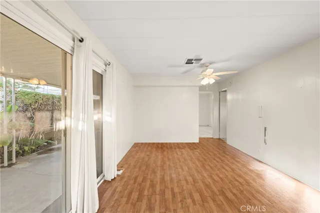 a view of a room with a ceiling fan and a window
