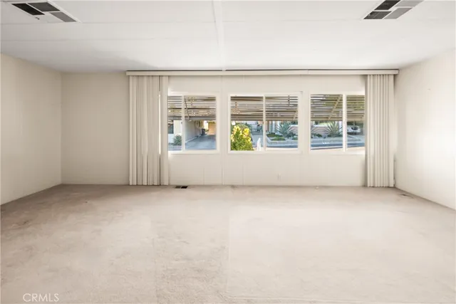 a view of a hallway with wooden floor windows and a kitchen