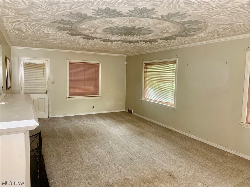 665 Dorchester Road Akron, OH 44320 - Photo 10 of 18 Carpeted spare room featuring crown molding