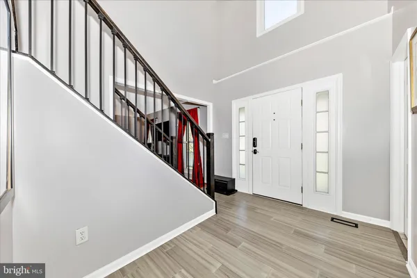 a view of a hallway with wooden floor and entryway