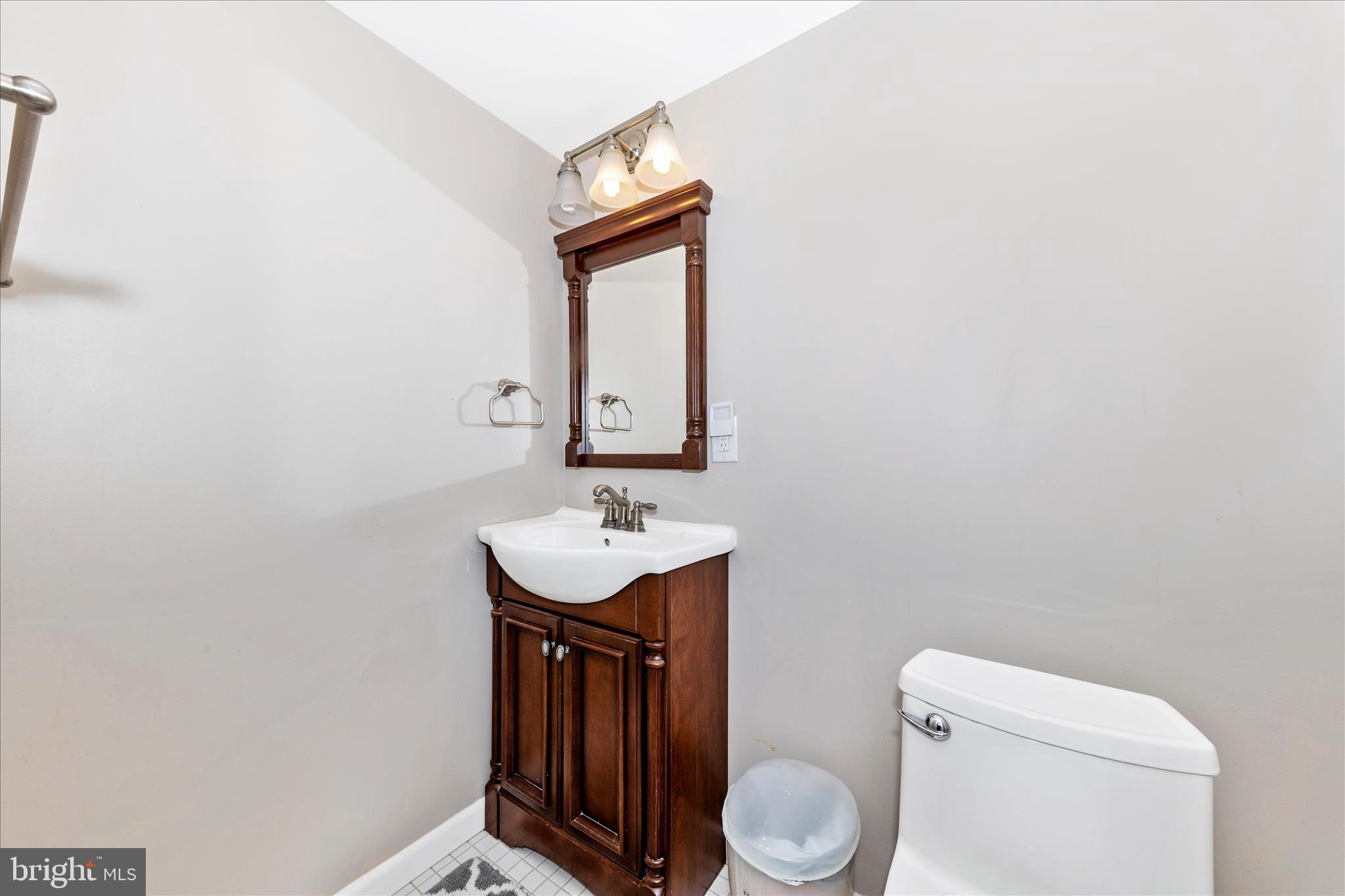 19010 Wootton Avenue Poolesville, MD 20837 - Photo 34 of 51 a bathroom with a toilet a sink and mirror