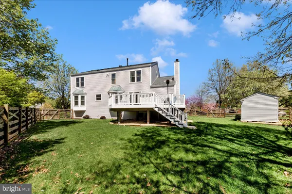 a view of a house with a deck and a yard