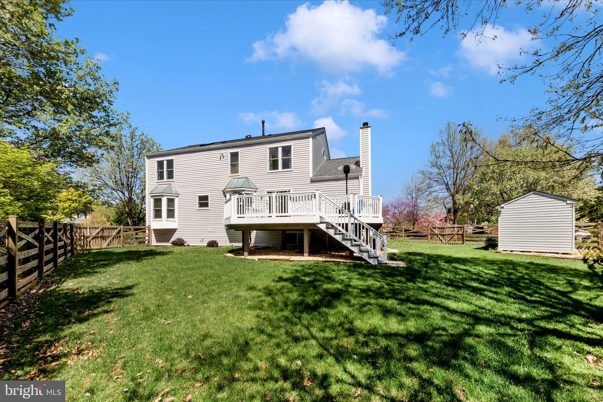 19010 Wootton Avenue Poolesville, MD 20837 - Photo 39 of 51 a view of a white house with a big yard and large trees