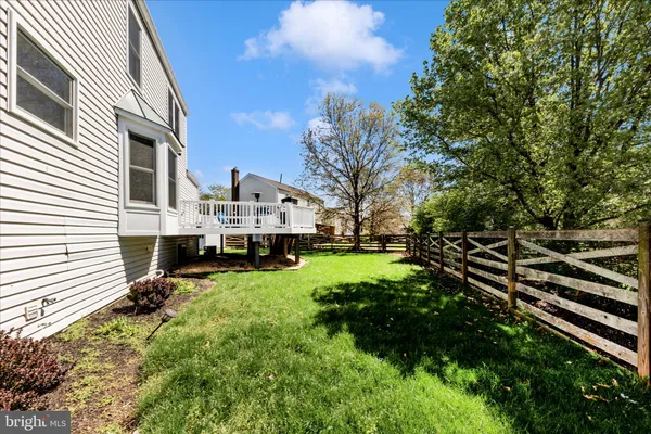 a view of a white house with a big yard and large trees