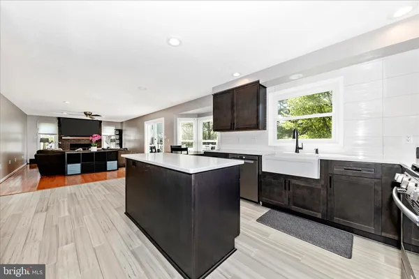 a large kitchen with stainless steel appliances granite countertop a sink dishwasher stove and oven with wooden floor