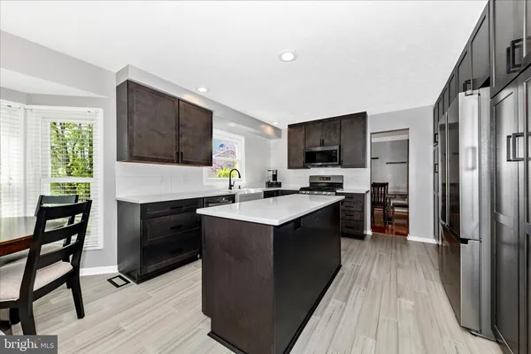 a kitchen with granite countertop a stove top oven and refrigerator