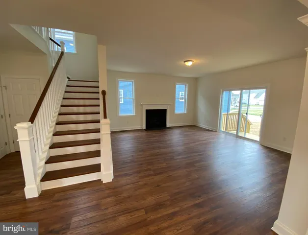 a view of a room with wooden floor and white walls