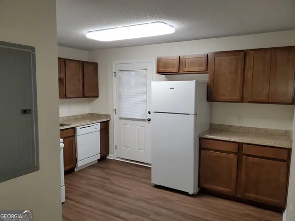 a kitchen with a refrigerator and a stove top oven