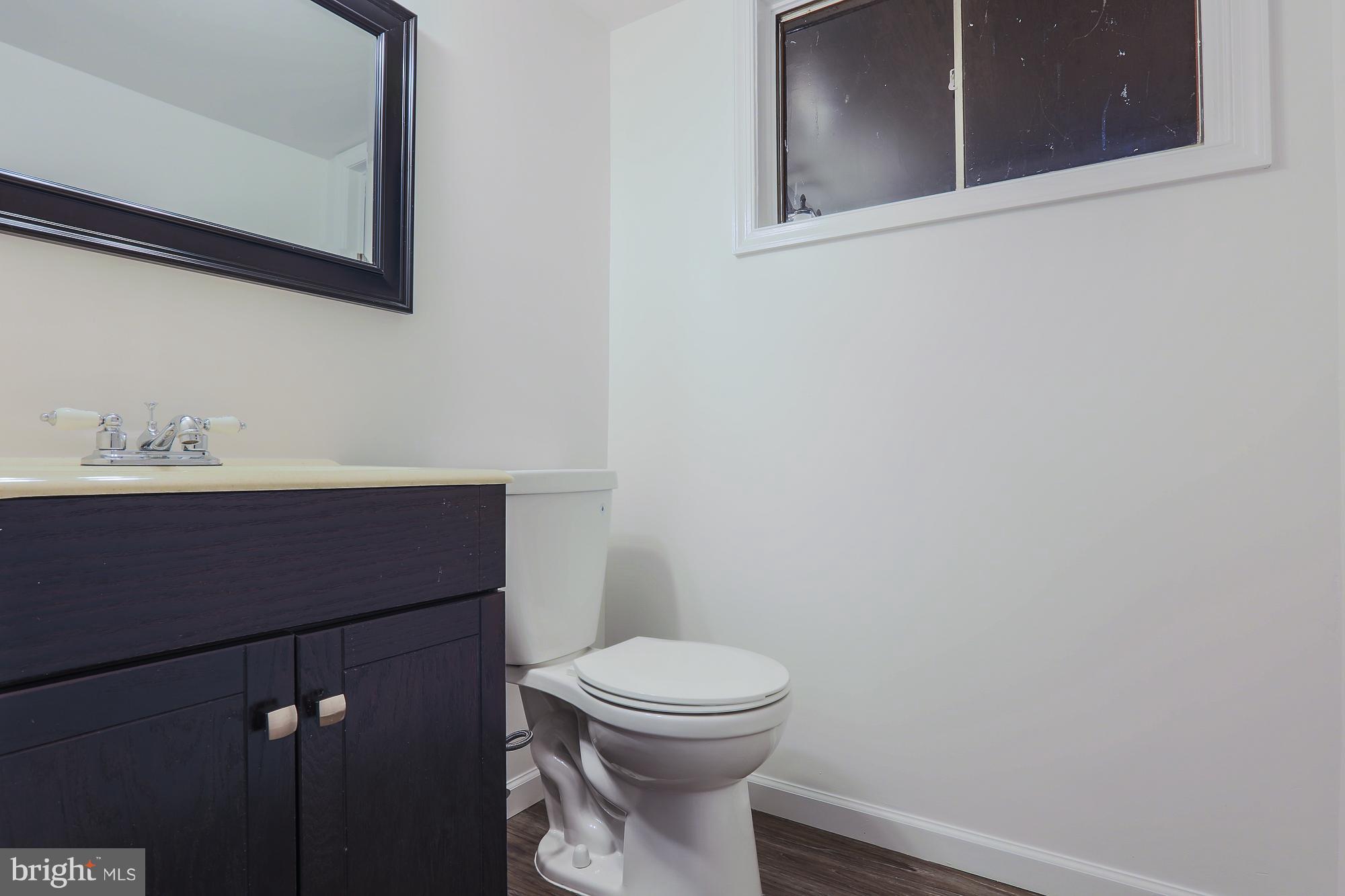 5625 Huntsmoor Road Baltimore, MD 21227 - Photo 14 of 30 a bathroom with a sink a toilet and mirror