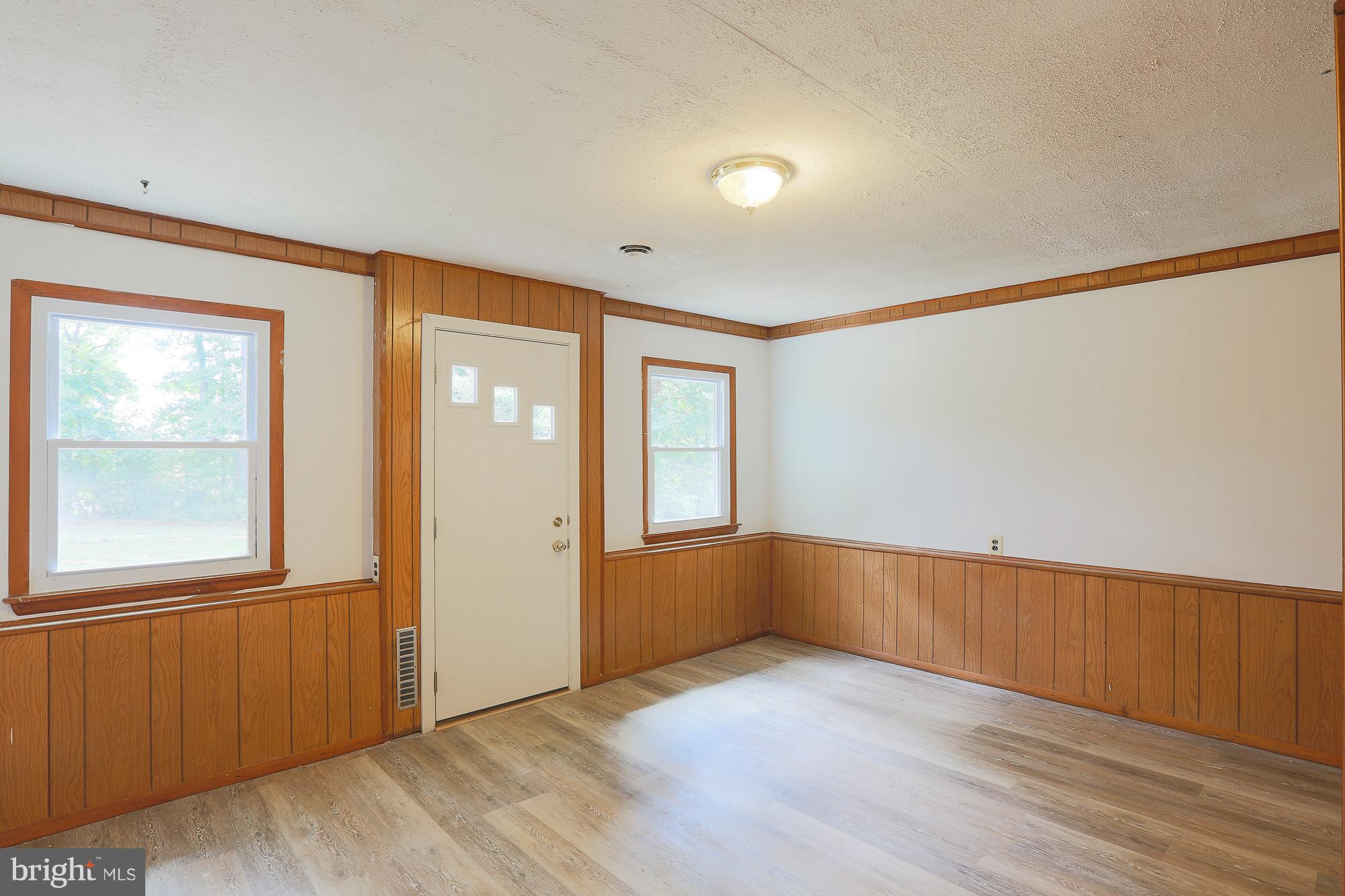 5625 Huntsmoor Road Baltimore, MD 21227 - Photo 16 of 30 an empty room with wooden floor and windows