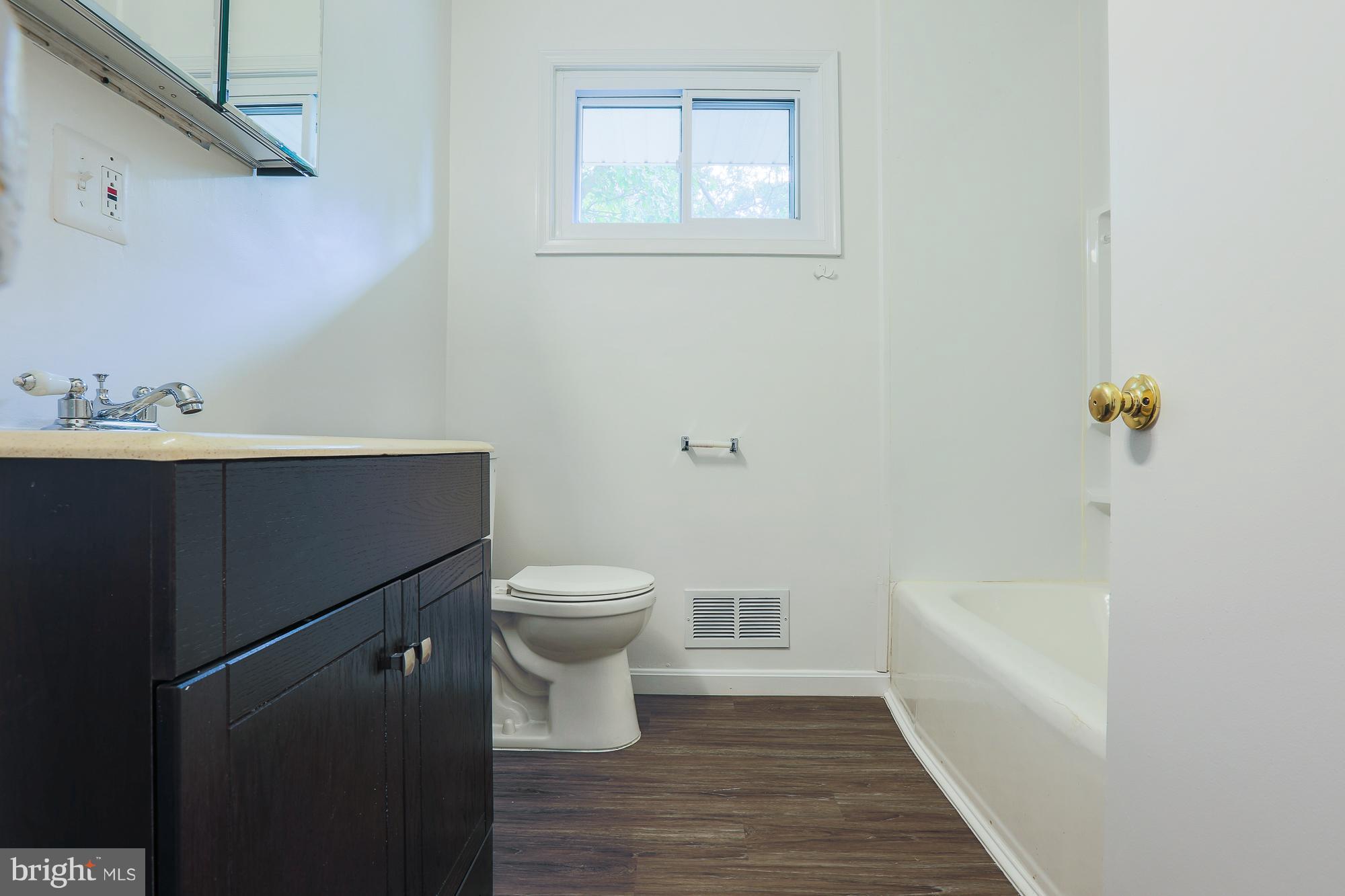 5625 Huntsmoor Road Baltimore, MD 21227 - Photo 9 of 30 a bathroom with a sink a toilet and bathtub