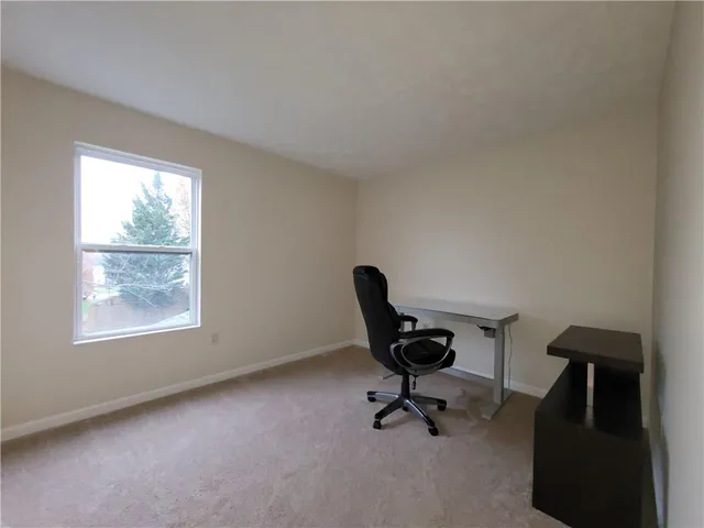 a view of a workspace with furniture and a window