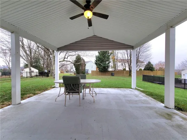 a view of a patio with a table chairs and a yard