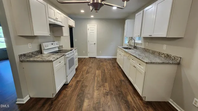 a kitchen with stainless steel appliances granite countertop a sink stove and cabinets