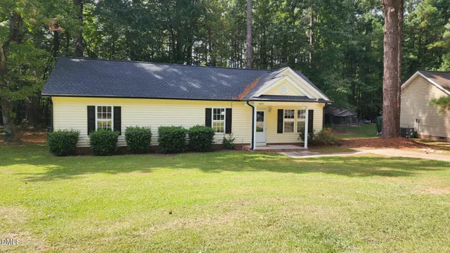 a view of a house with swimming pool next to a yard