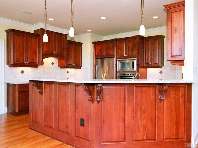 1629 Stannard Trail Raleigh, NC 27612 - Photo 5 of 12 a kitchen with kitchen island granite countertop wooden cabinets and stainless steel appliances