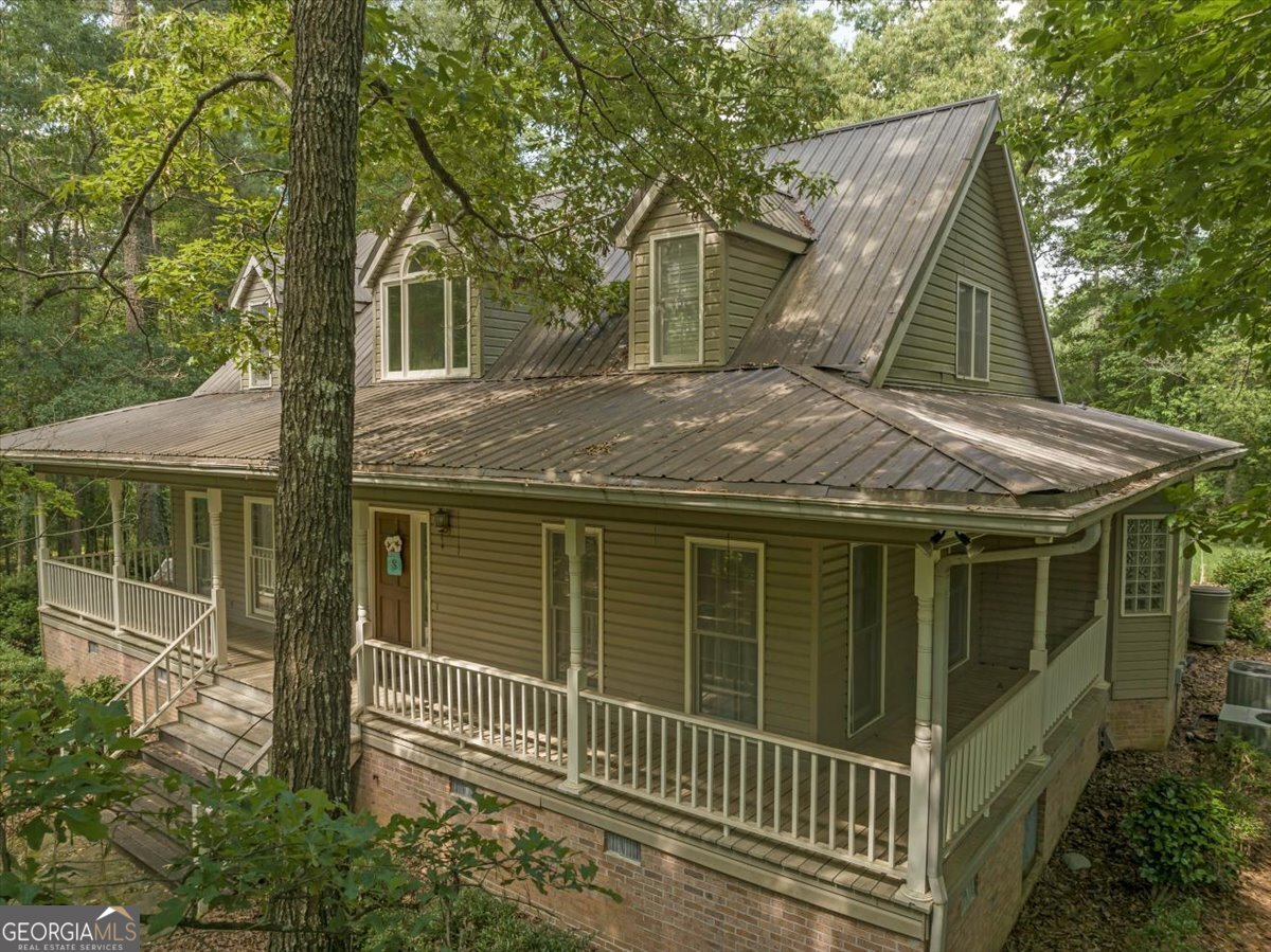 a view of a house with a small yard and a large tree