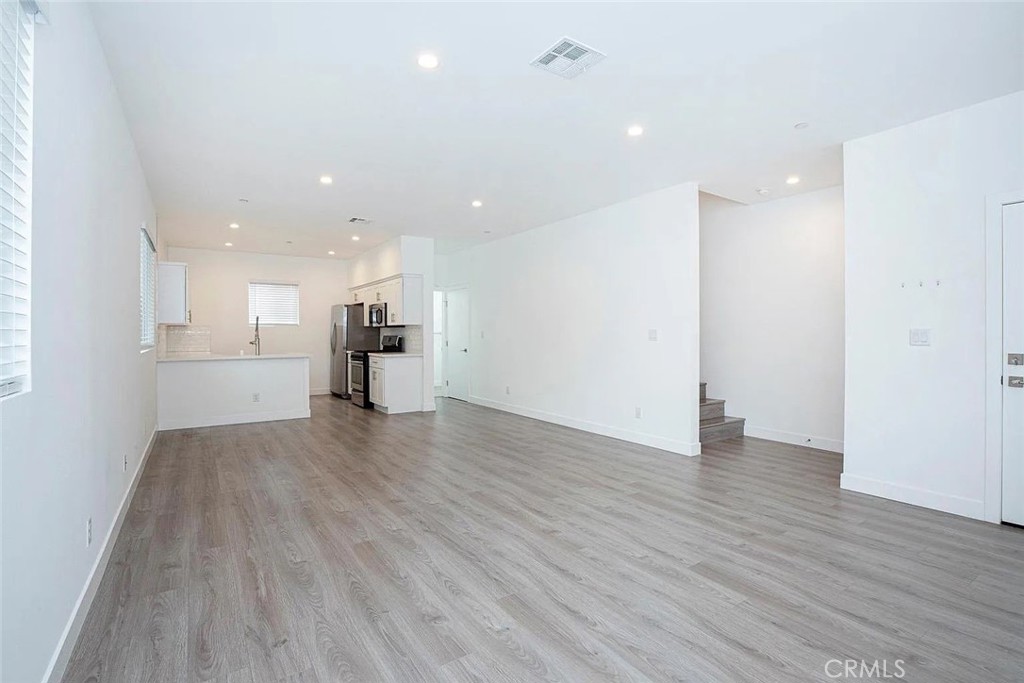5026 1/2 Cleon Avenue North Hollywood, CA 91601 - Photo 15 of 19 a view of an empty room and a kitchen with wooden floor