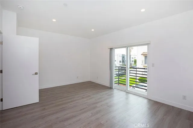 an empty room with wooden floor and a window