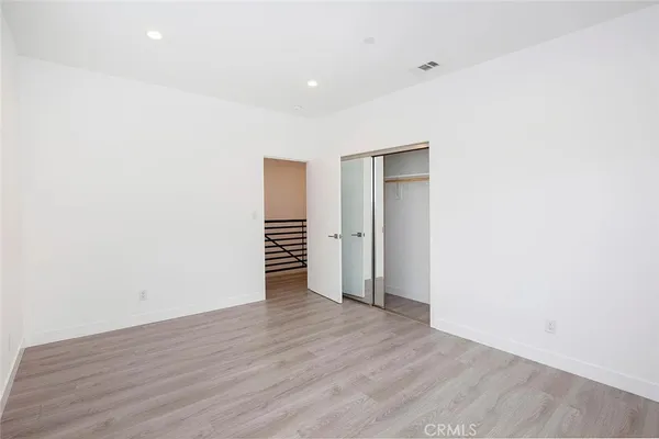 a view of empty room with wooden floor