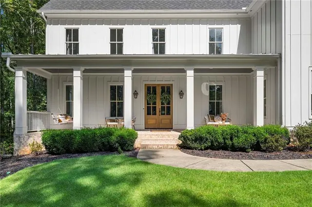 a view of a patio with table and chairs potted plants and floor to ceiling window