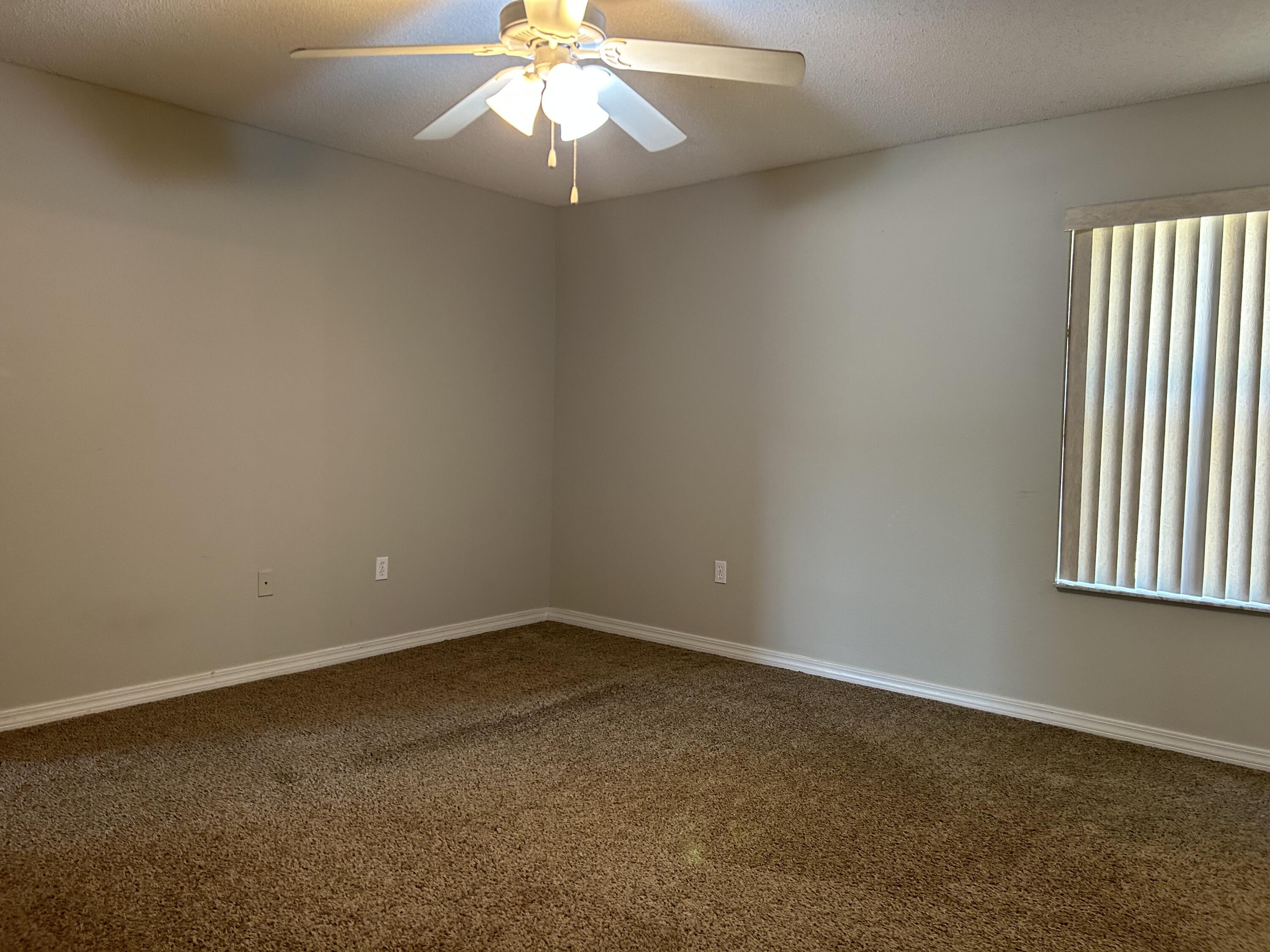 203 Cabana Way Crestview, FL 32536 - Photo 14 of 25 an empty room with a chandelier fan and windows