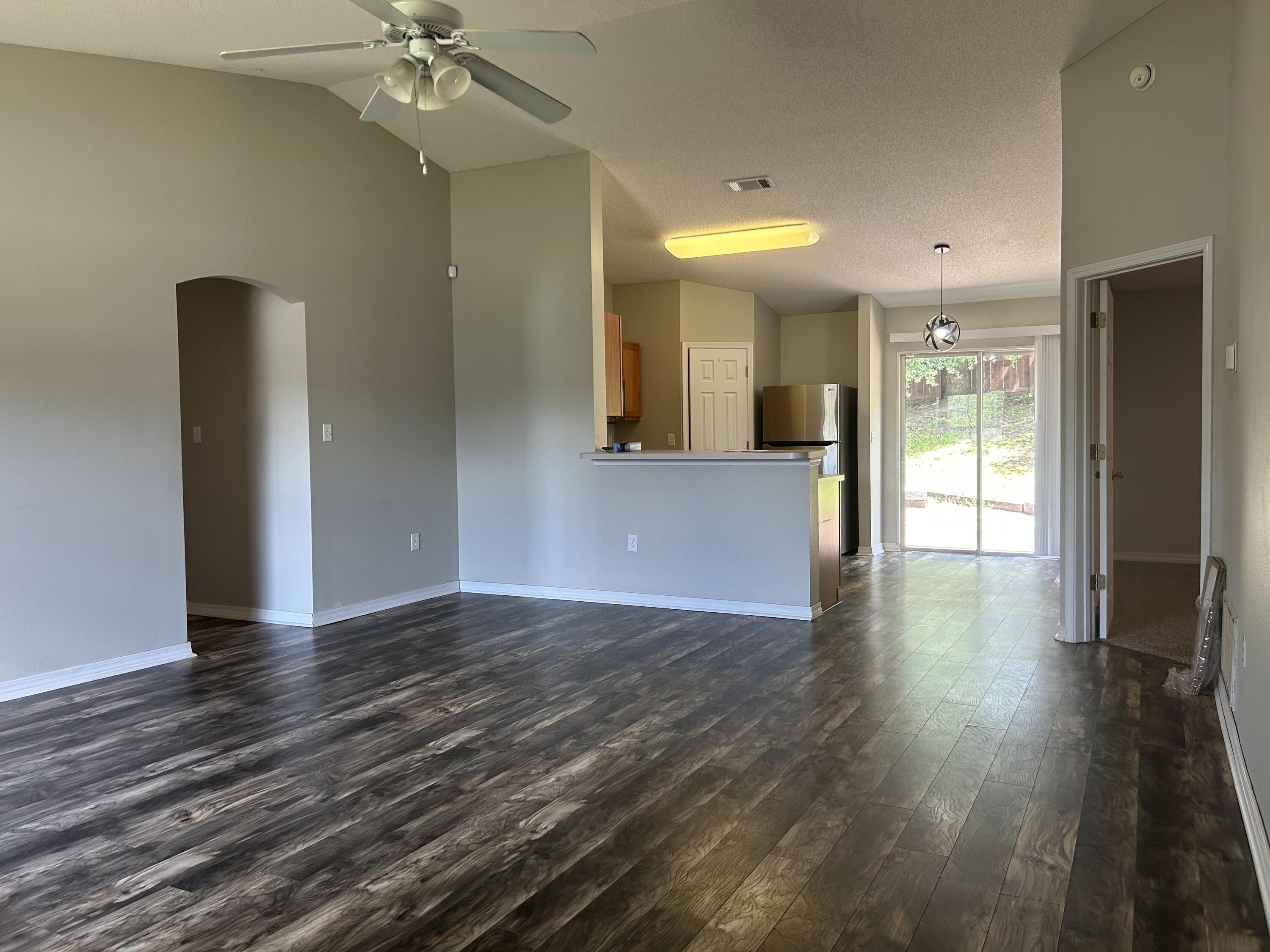 203 Cabana Way Crestview, FL 32536 - Photo 4 of 25 an empty room with wooden floor and windows