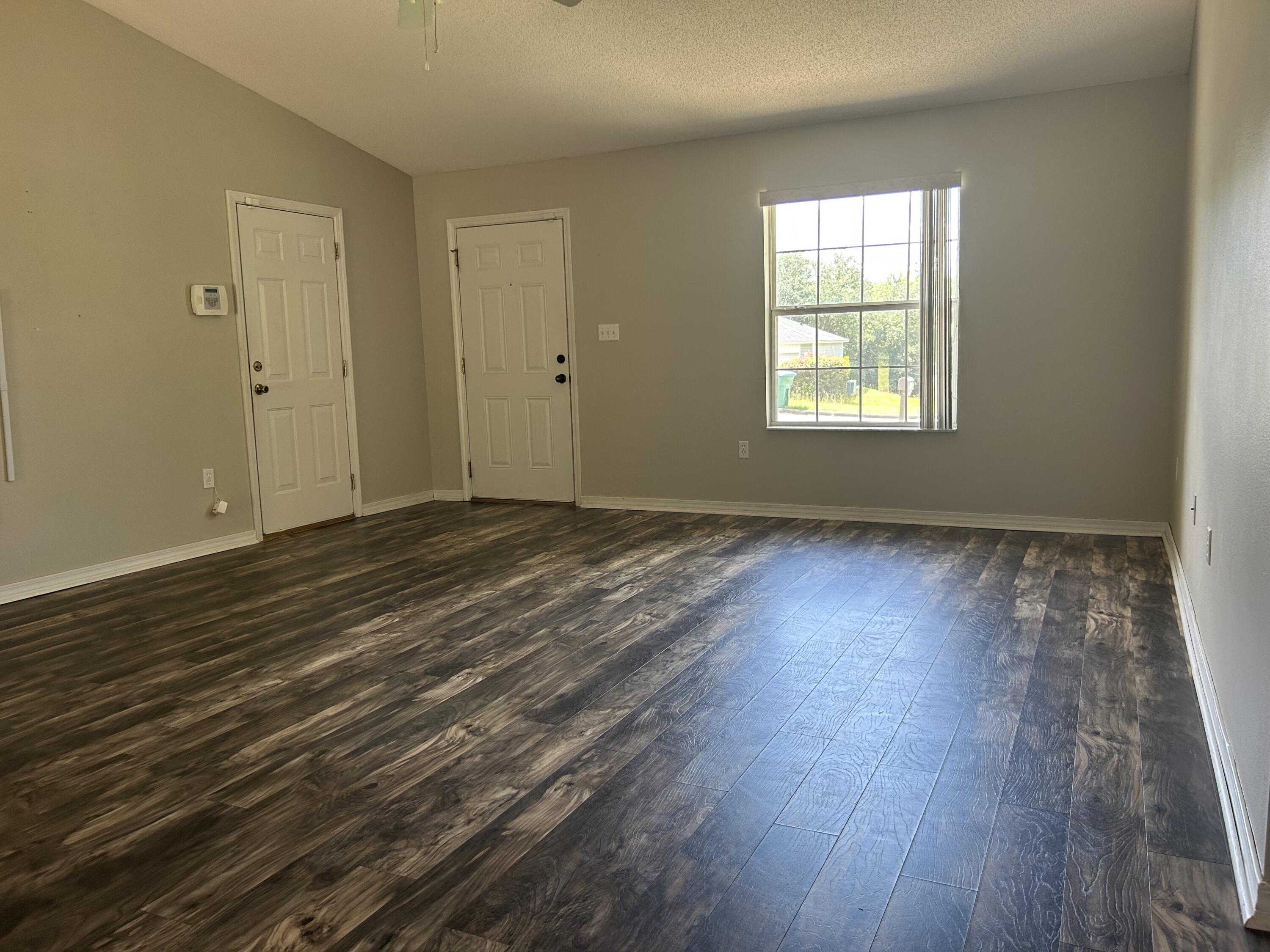 203 Cabana Way Crestview, FL 32536 - Photo 6 of 25 an empty room with wooden floor and windows
