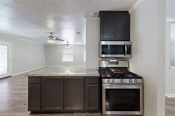 a kitchen with granite countertop a stove and a microwave