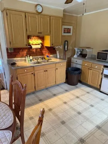 a kitchen with sink a stove and chairs