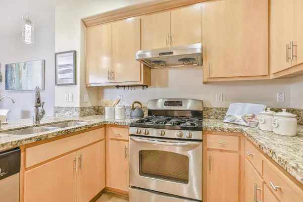 a kitchen with granite countertop white cabinets and white appliances