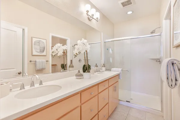 a en suite bathroom with a double vanity sink and a mirror