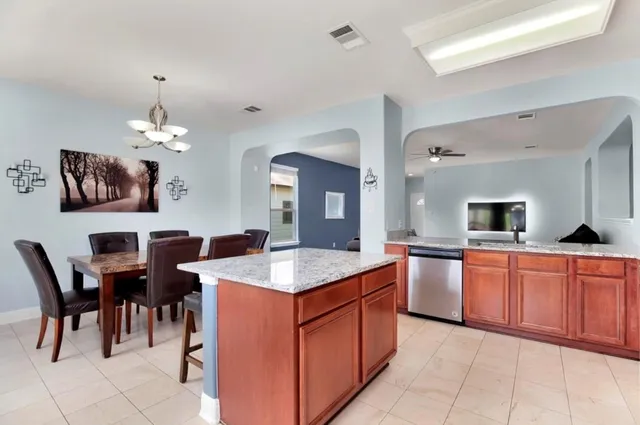 a kitchen with a stove a sink a dining table and chairs
