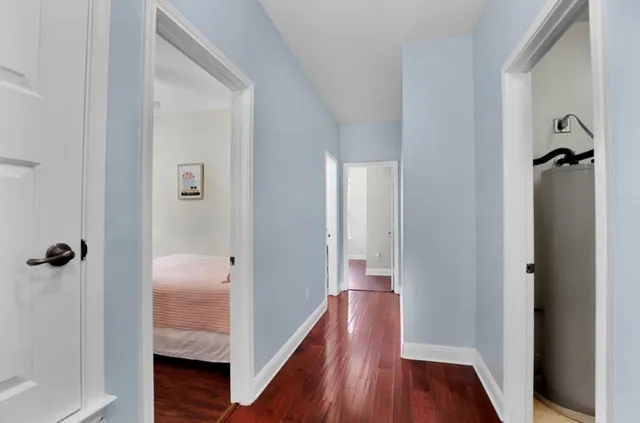 a view of a hallway with wooden floor and closet