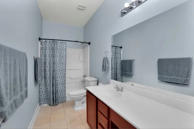 a bathroom with a double vanity sink toilet and shower