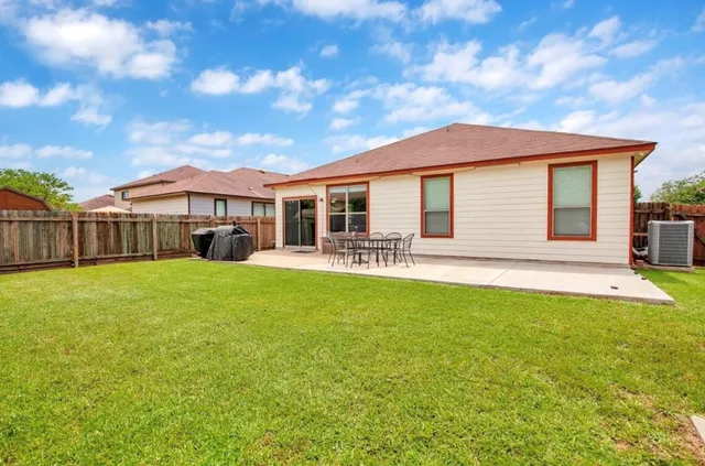 a view of a house with a backyard and a patio