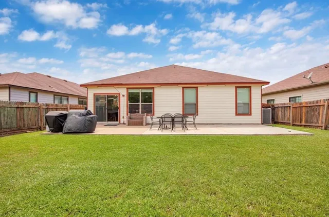 a patio with table and chairs and potted plants