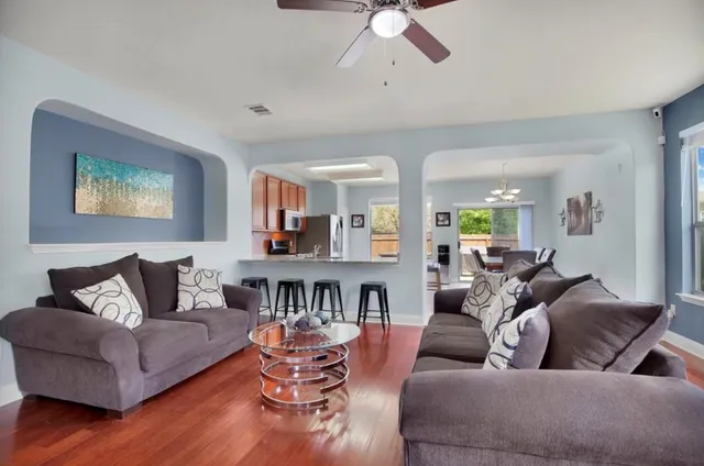 a living room with furniture and a wooden floor