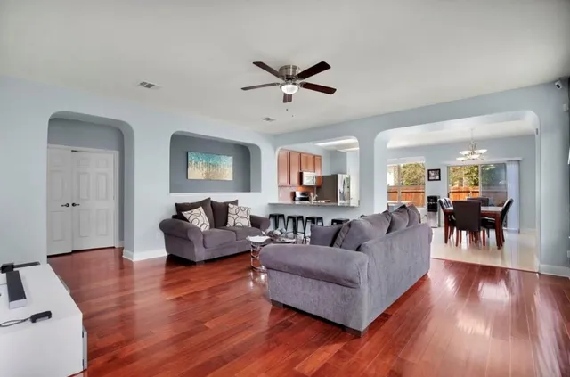 a living room with furniture and wooden floor