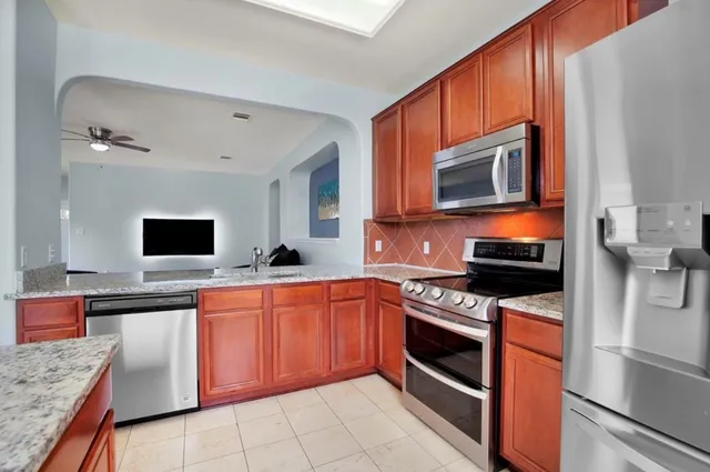 a kitchen with stainless steel appliances granite countertop a stove microwave and sink